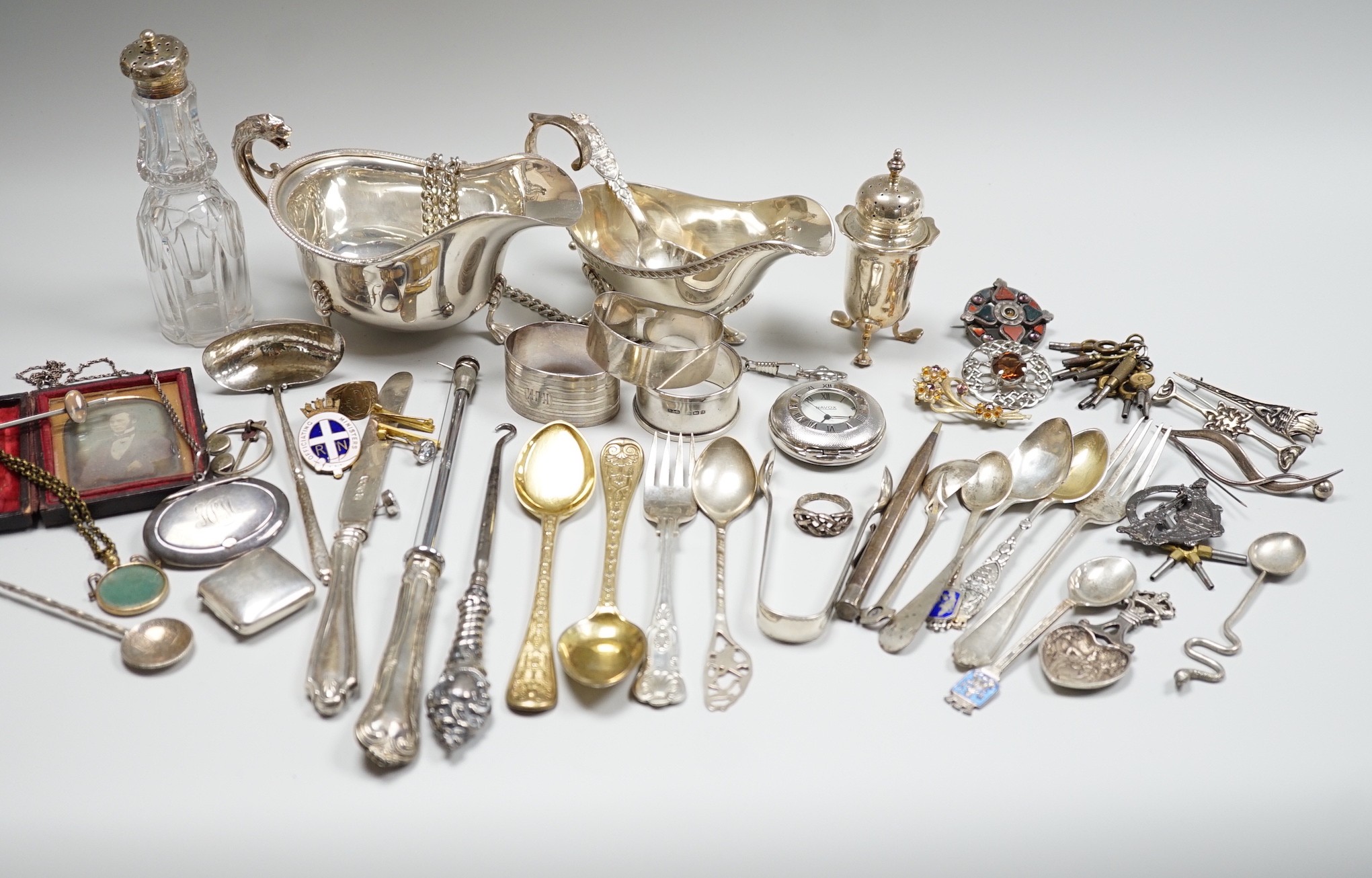 Sundry small silver including two sauceboats, napkin rings, mounted glass condiment bottle, pepperette, pair of silver gilt preserve spoons, minor flatware including white metal, a 1920's Georg Jensen silver cream ladle,